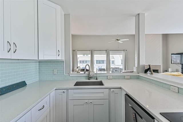 8111 Broadway St Unit 7, Galveston, TX 77554 - kitchen with a sink, stainless steel dishwasher, a ceiling fan, tasteful backsplash, and white cabinets