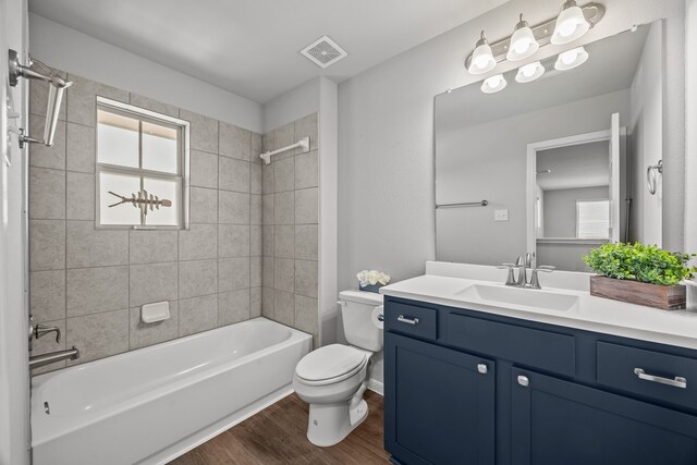 10902 Webber Ln, Texas City, TX 77591 - bathroom featuring wood finished floors, toilet, tub / shower combination, and vanity