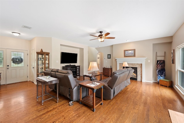 6803 E Treaschwig Rd, Spring, TX 77373 - living area featuring light wood-style flooring, a glass covered fireplace, ceiling fan, and baseboards