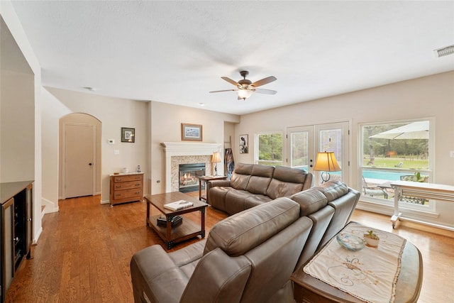 6803 E Treaschwig Rd, Spring, TX 77373 - living area with a glass covered fireplace, light wood finished floors, a ceiling fan, and arched walkways