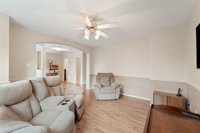 6803 E Treaschwig Rd, Spring, TX 77373 - living room featuring arched walkways, light wood-style floors, a ceiling fan, and baseboards
