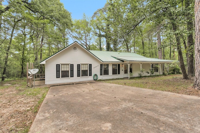 24614 Spruce, Huntsville, TX 77320 - view of front of property with driveway, a chimney, metal roof, and a deck
