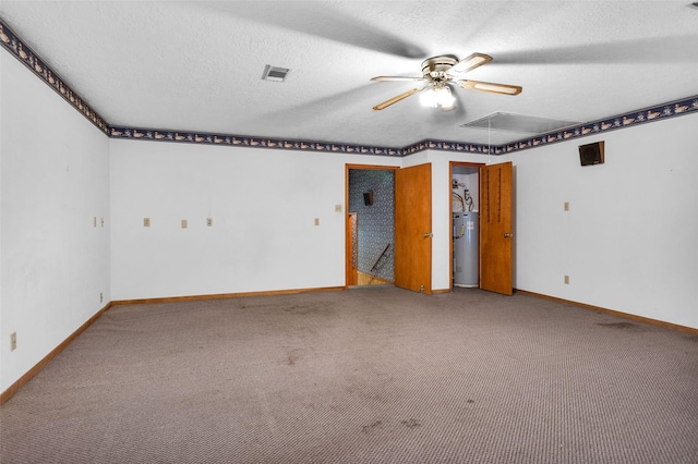 24614 Spruce, Huntsville, TX 77320 - carpeted spare room with attic access, water heater, a ceiling fan, baseboards, and a textured ceiling