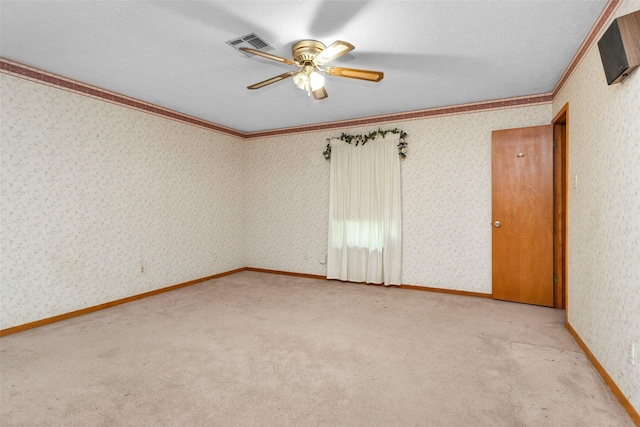 24614 Spruce, Huntsville, TX 77320 - spare room featuring ceiling fan, ornamental molding, light colored carpet, and wallpapered walls