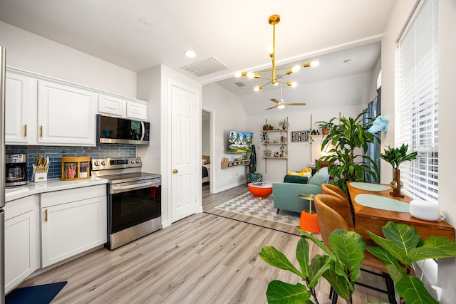 14742 Timbergreen Dr, Magnolia, TX 77355 - kitchen featuring stainless steel appliances, decorative backsplash, light countertops, white cabinetry, and light wood finished floors