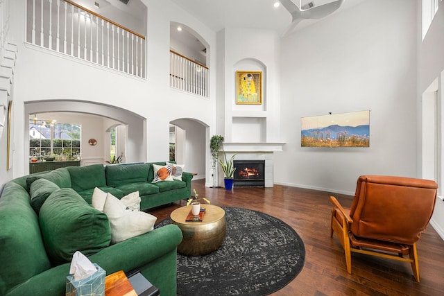 14742 Timbergreen Dr, Magnolia, TX 77355 - living room with a towering ceiling, wood finished floors, a warm lit fireplace, baseboards, and recessed lighting