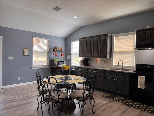3876 Hummingbird, Bedias, TX 77831 - kitchen featuring black / electric stove, a sink, lofted ceiling, light wood finished floors, and backsplash