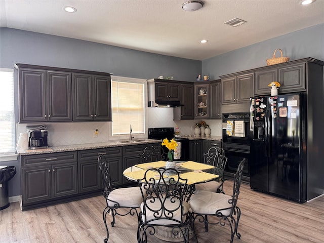 3876 Hummingbird, Bedias, TX 77831 - kitchen with black appliances, a sink, under cabinet range hood, decorative backsplash, and recessed lighting