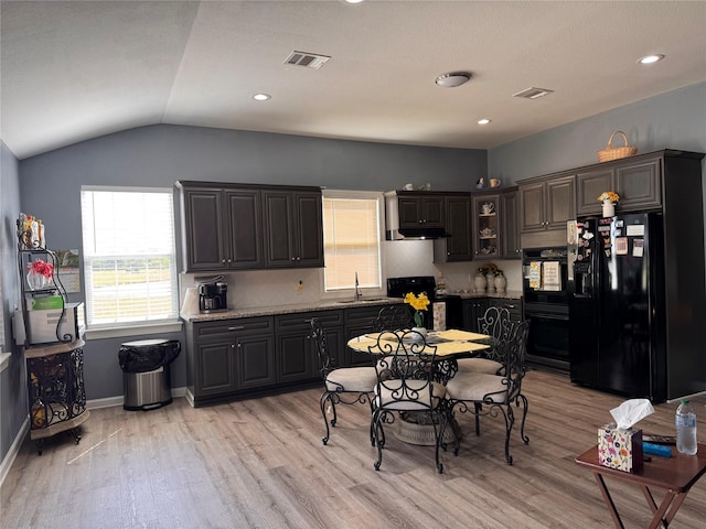 3876 Hummingbird, Bedias, TX 77831 - kitchen with black appliances, a sink, light wood-style flooring, lofted ceiling, and under cabinet range hood