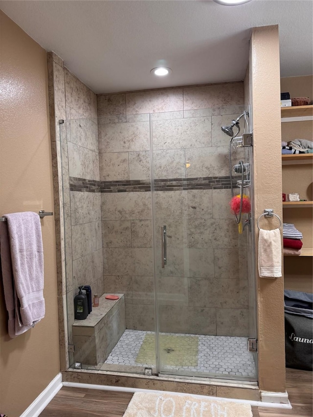 3876 Hummingbird, Bedias, TX 77831 - bathroom featuring wood finished floors, a shower stall, baseboards, a spacious closet, and recessed lighting