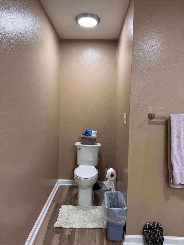 3876 Hummingbird, Bedias, TX 77831 - bathroom featuring wood finished floors, toilet, and baseboards