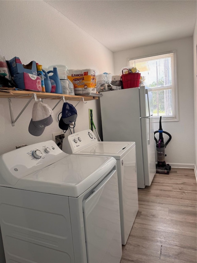 3876 Hummingbird, Bedias, TX 77831 - clothes washing area with washer and clothes dryer, light wood finished floors, and baseboards