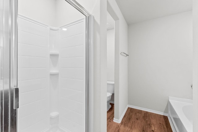 full bathroom featuring a stall shower, wood finished floors, toilet, and baseboards