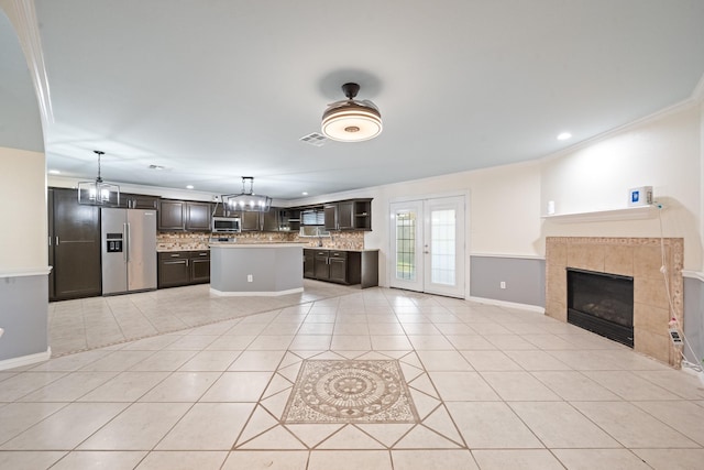 20151 Pioneer Ridge Dr, Cypress, TX 77433 - kitchen with appliances with stainless steel finishes, backsplash, open floor plan, light tile patterned flooring, and light countertops
