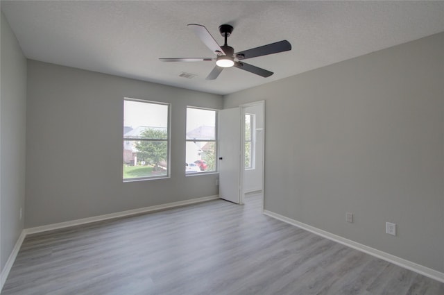 11623 Silent Elm St, Houston, TX 77044 - empty room featuring light wood-style floors, baseboards, ceiling fan, and a textured ceiling