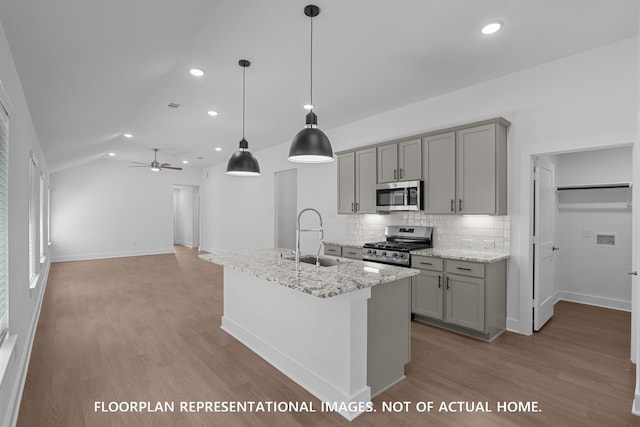 20526 Draper Rd, Tomball, TX 77377 - kitchen featuring appliances with stainless steel finishes, gray cabinets, a sink, light wood-type flooring, and backsplash