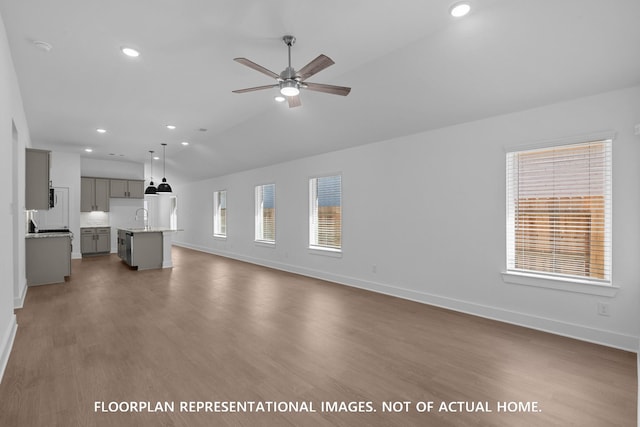 20526 Draper Rd, Tomball, TX 77377 - unfurnished living room with a sink, ceiling fan, baseboards, vaulted ceiling, and wood finished floors