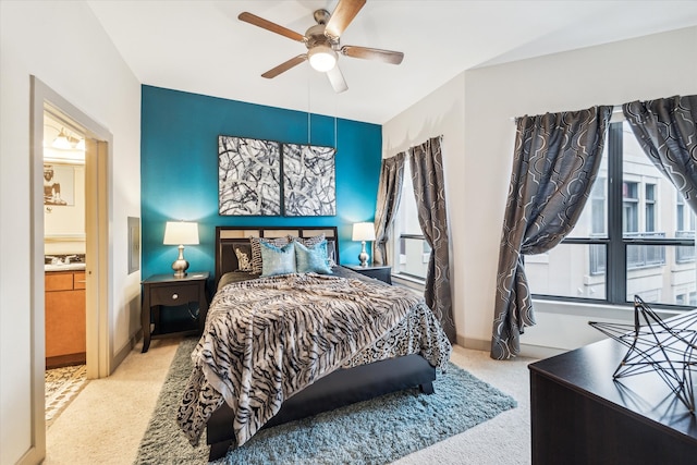carpeted bedroom featuring multiple windows, ceiling fan, a sink, and baseboards