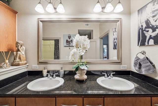 bathroom featuring a chandelier and double vanity
