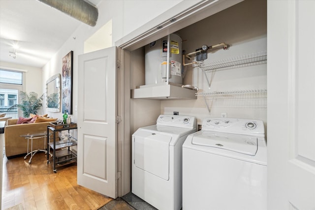 washroom featuring washing machine and dryer, gas water heater, and light wood-type flooring