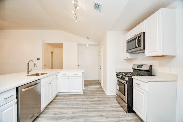 4618 Leicester Way, Missouri City, TX 77459 - kitchen featuring stainless steel appliances, a sink, lofted ceiling, light wood-style floors, and white cabinets
