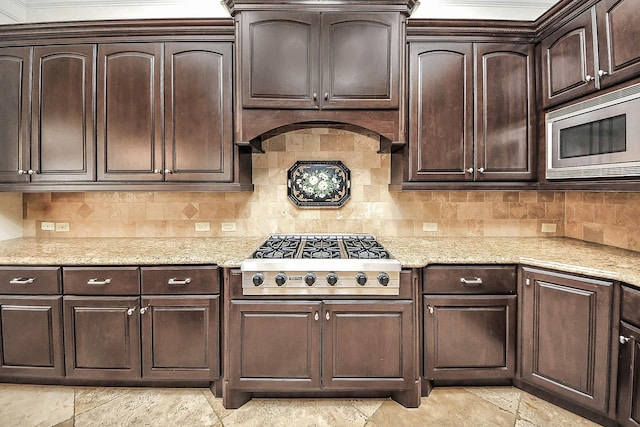 5701 Sugar Hill Dr, Houston, TX 77057 - kitchen featuring appliances with stainless steel finishes, dark brown cabinetry, light stone countertops, and decorative backsplash