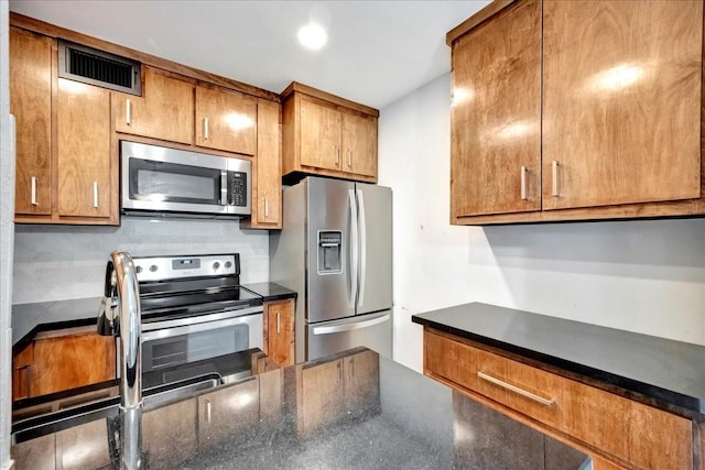 411 Westmoreland St Unit 1, Houston, TX 77006 - kitchen featuring appliances with stainless steel finishes, brown cabinetry, and dark stone counters