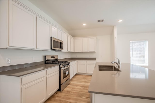 22065 Juniper Crossing Dr, New Caney, TX 77357 - kitchen featuring stainless steel appliances, a sink, an island with sink, recessed lighting, and white cabinetry