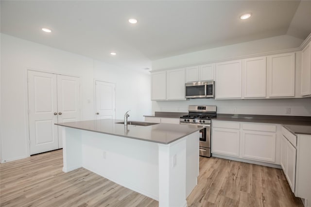 22065 Juniper Crossing Dr, New Caney, TX 77357 - kitchen with stainless steel appliances, a sink, light wood-style floors, white cabinetry, and recessed lighting