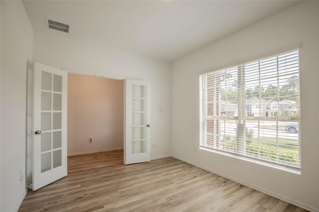 22065 Juniper Crossing Dr, New Caney, TX 77357 - spare room featuring french doors, light wood-style flooring, and baseboards