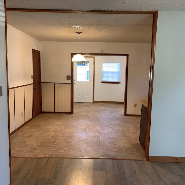 324 Persimmon Rd, Onalaska, TX 77360 - entryway featuring a textured ceiling, wainscoting, and light tile patterned floors