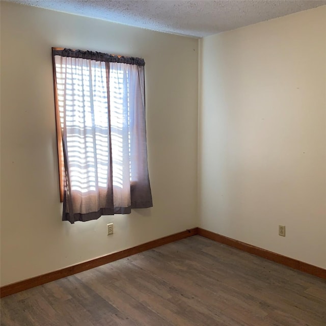324 Persimmon Rd, Onalaska, TX 77360 - empty room with wood finished floors, a textured ceiling, and baseboards