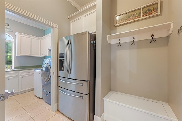 711 Valley Commons Dr, Huffman, TX 77336 - laundry room featuring cabinet space, ornamental molding, light tile patterned flooring, and washer / dryer