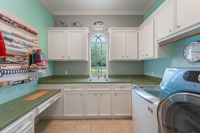 711 Valley Commons Dr, Huffman, TX 77336 - laundry room with washing machine and dryer, cabinet space, light tile patterned floors, and crown molding