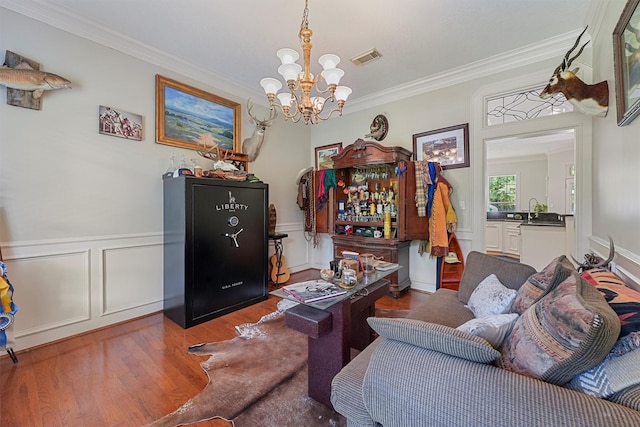 711 Valley Commons Dr, Huffman, TX 77336 - living area with wood finished floors, a chandelier, ornamental molding, a decorative wall, and wainscoting