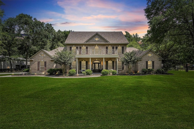 711 Valley Commons Dr, Huffman, TX 77336 - colonial home featuring a balcony, a front yard, brick siding, and a porch