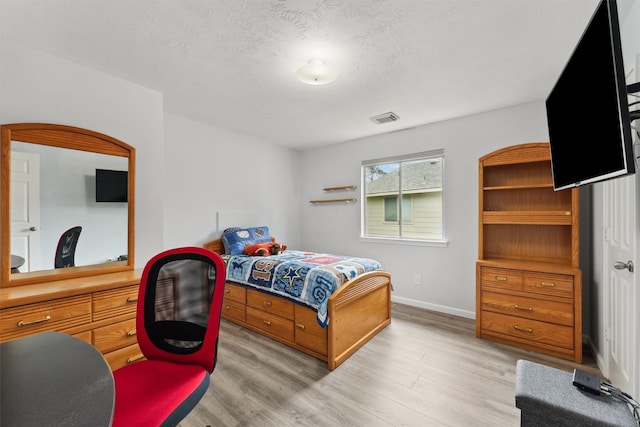 17150 Mountain Crest Dr, Spring, TX 77379 - bedroom featuring light wood-style flooring, baseboards, and a textured ceiling