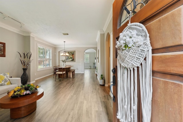 17150 Mountain Crest Dr, Spring, TX 77379 - living area featuring ornamental molding, arched walkways, wood finished floors, a chandelier, and rail lighting