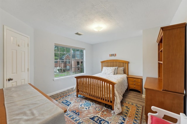17150 Mountain Crest Dr, Spring, TX 77379 - bedroom featuring baseboards, a textured ceiling, and wood finished floors