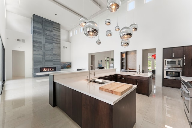 3214 W Benders Landing Blvd, Spring, TX 77386 - kitchen featuring stainless steel appliances, a sink, a high ceiling, a large island, and light countertops
