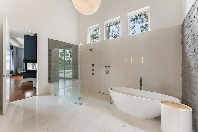 3214 W Benders Landing Blvd, Spring, TX 77386 - full bathroom featuring a high ceiling, marble finish floors, healthy amount of natural light, an enclosed shower, and a freestanding tub