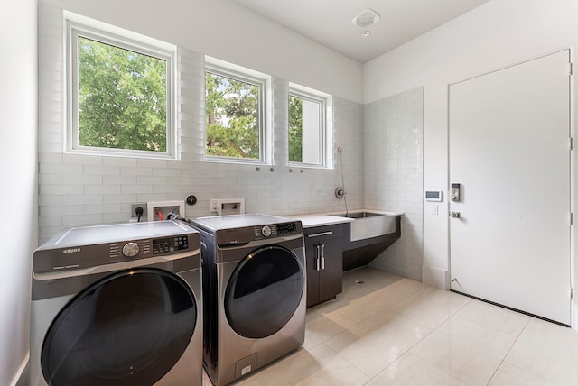 3214 W Benders Landing Blvd, Spring, TX 77386 - washroom with cabinet space, washing machine and clothes dryer, light tile patterned floors, and tile walls