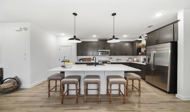 106 Kickapoo Dr, Anahuac, TX 77514 - kitchen featuring appliances with stainless steel finishes, light wood finished floors, light countertops, a breakfast bar, and recessed lighting
