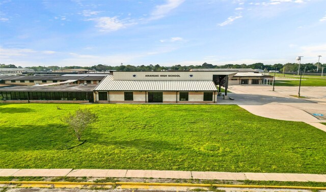 106 Kickapoo Dr, Anahuac, TX 77514 - view of front of house featuring metal roof, a front yard, and stucco siding