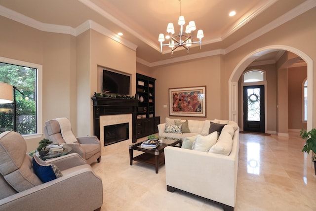 16114 Villa Fontana Way, Houston, TX 77068 - living room with a fireplace, arched walkways, a chandelier, a tray ceiling, and crown molding