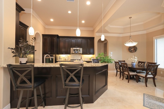 16114 Villa Fontana Way, Houston, TX 77068 - kitchen featuring appliances with stainless steel finishes, arched walkways, tasteful backsplash, light stone countertops, and ornamental molding