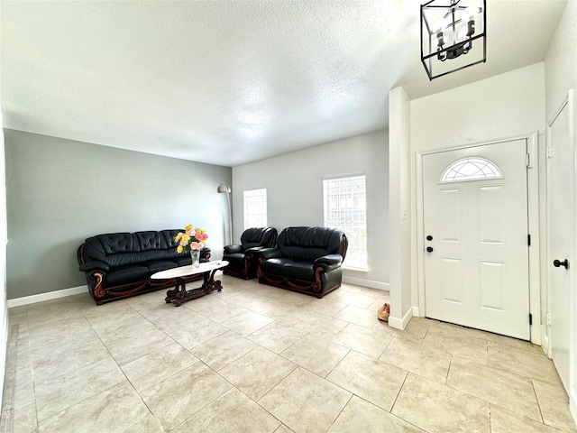 11127 Village Bend Ln Unit 1127, Houston, TX 77072 - foyer featuring a textured ceiling, light tile patterned flooring, a chandelier, and baseboards