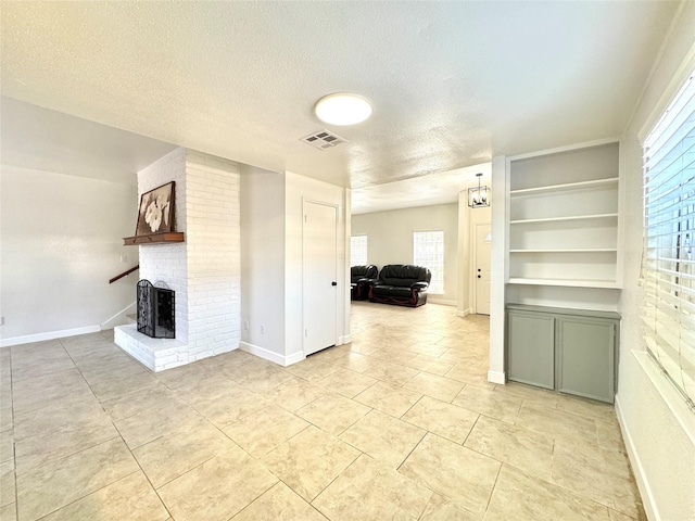 11127 Village Bend Ln Unit 1127, Houston, TX 77072 - unfurnished living room with a fireplace, a textured ceiling, light tile patterned floors, and baseboards