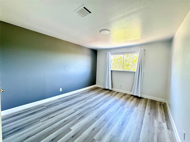 11127 Village Bend Ln Unit 1127, Houston, TX 77072 - unfurnished room with wood finished floors, baseboards, and a textured ceiling