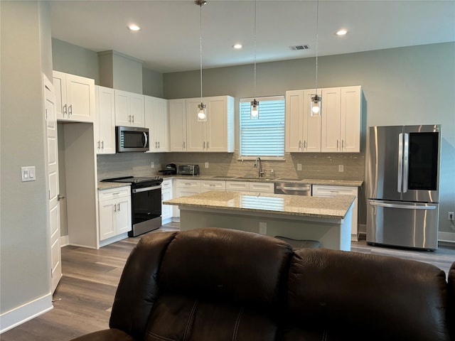 170 Nuuanu Ln, Bastrop, TX 78602 - kitchen featuring stainless steel appliances, a sink, white cabinetry, tasteful backsplash, and light stone countertops